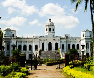 White colonial Tajhat palace surrounded by green gardens in Rangpur, Bangladesh.