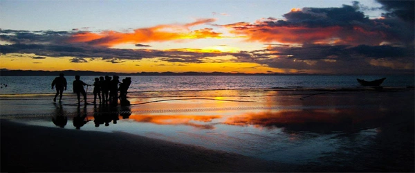 Moheshkhali beach sunset, Chittagong, with silhouettes of people walking along the shoreline.