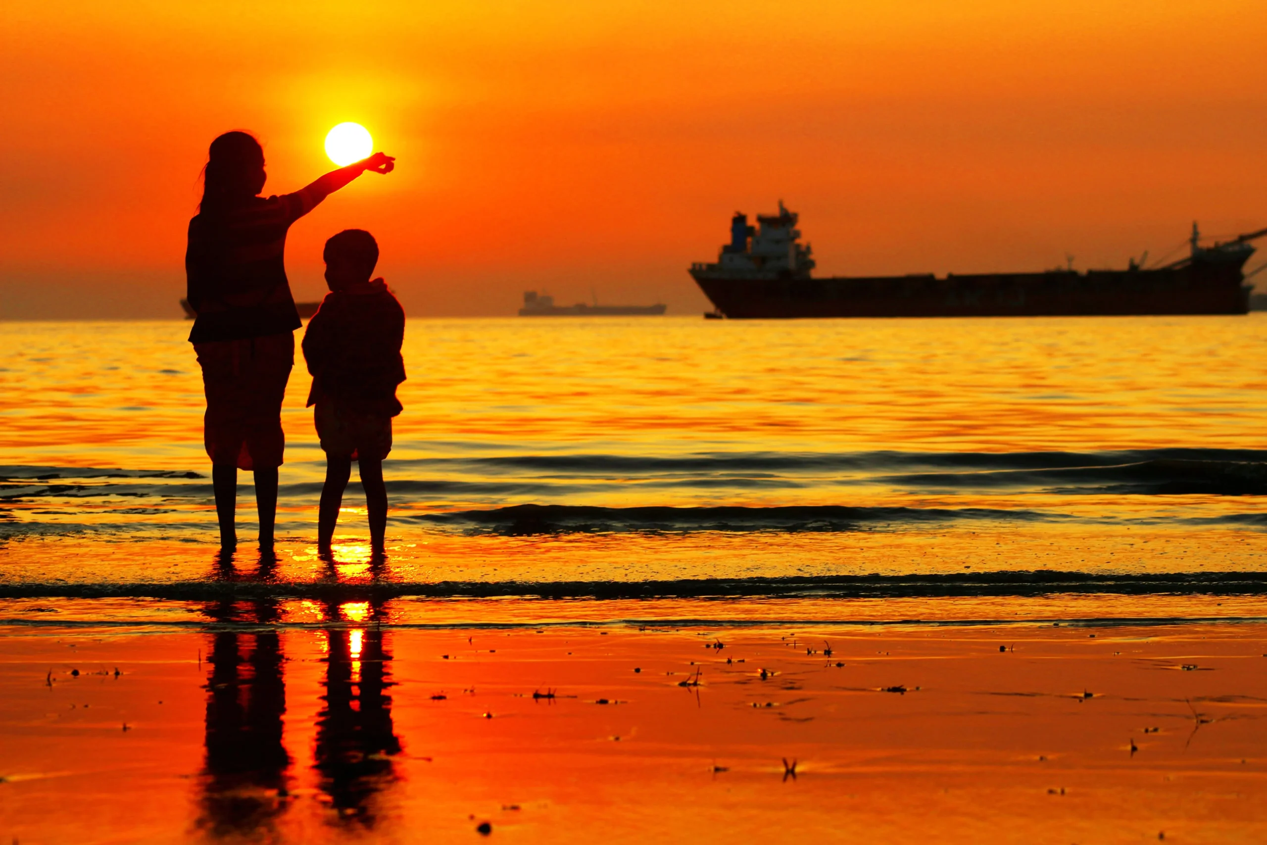 Children watching a spectacular sunset over Cox's Bazar, the world's longest natural sea beach, during a Discover Bangladesh tour.